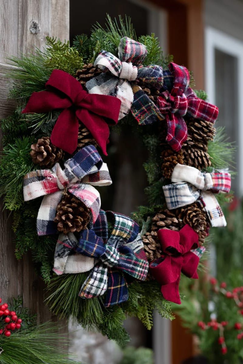 25. Christmas wreath made from an old flannel shirt, adorned with pinecones and plaid ribbons.