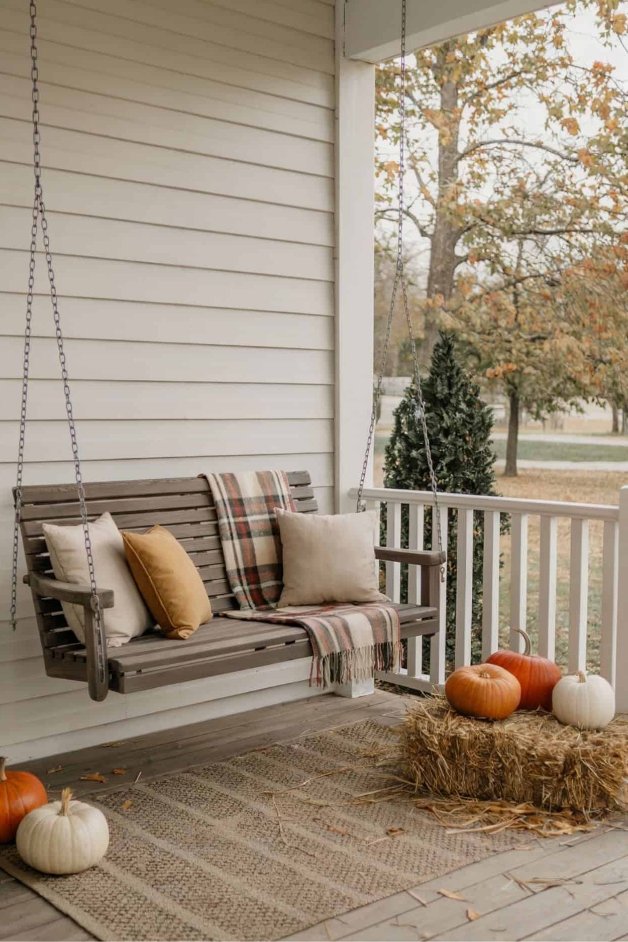 Neutral Porch Swing: Cozy Up with Fall Pillows and Pumpkins