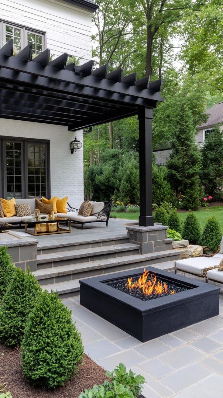 21. Black Pergola Centered Around a Fire Pit